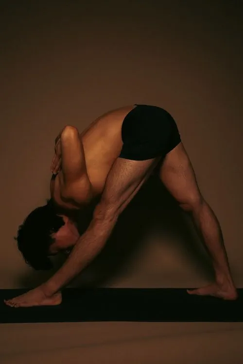A practitioner in a standing forward fold